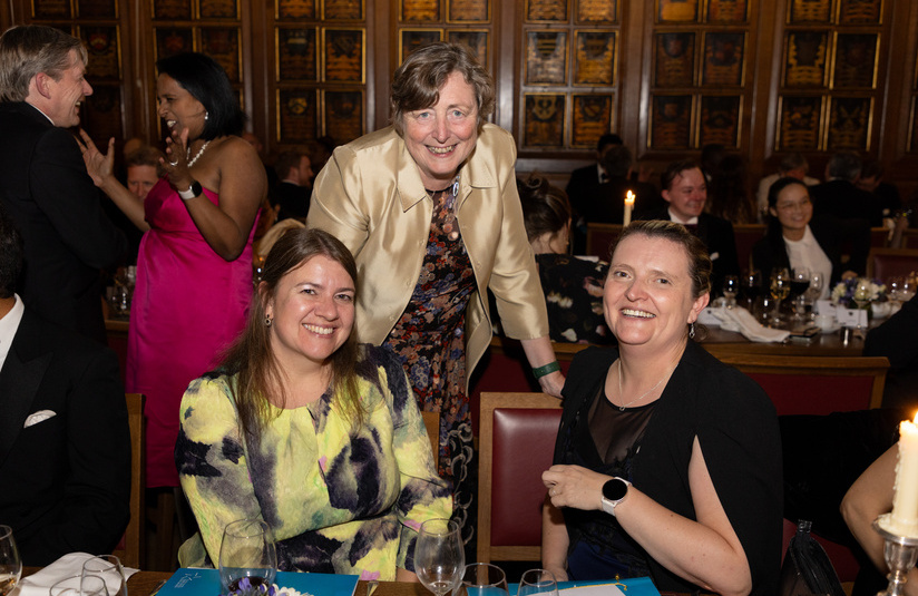 A photo of three people smiling at the camera