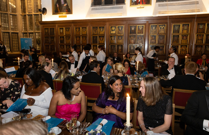 A photo of people talking while sitting at dinner tables