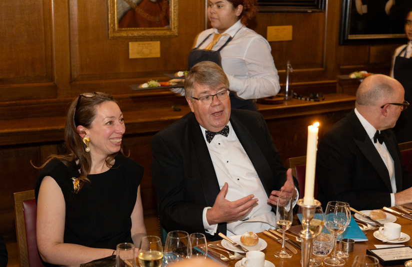 A photo of people sitting at a dinner table talking and happy