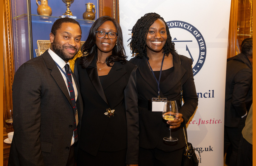 A photo of three people smiling at the camera