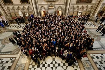 Around 350 women silks standing together in the Royal Courts of Justice. The photograph is taken from above.