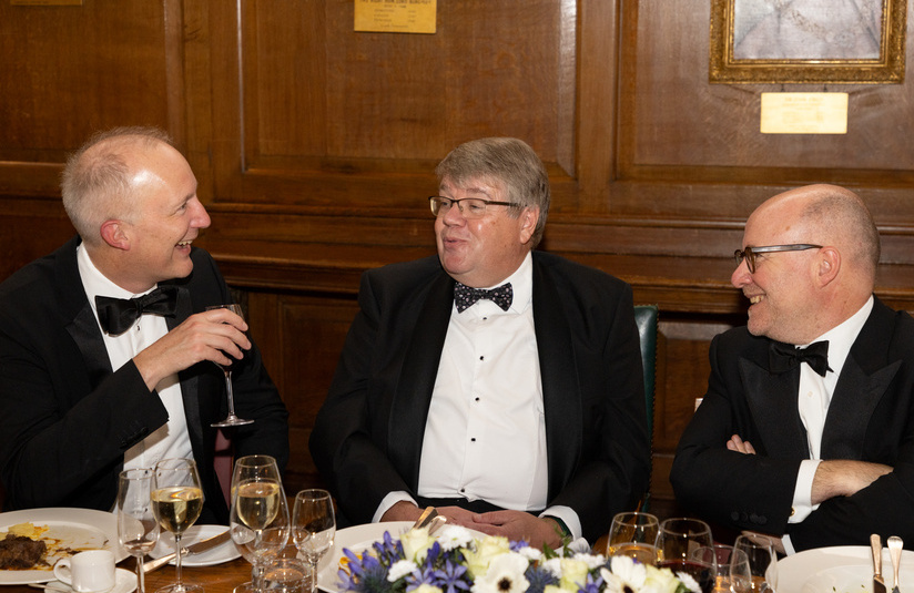 A photo of three people talking and laughing while seated