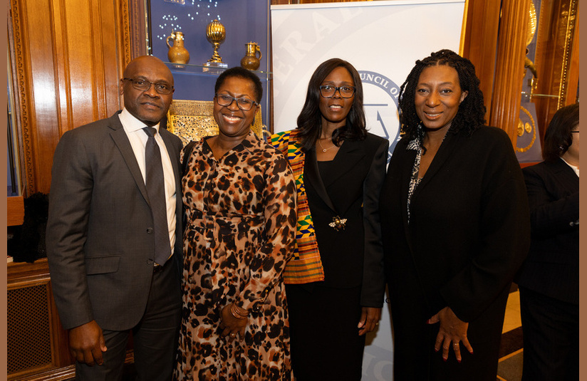 A photo of four people smiling at the camera