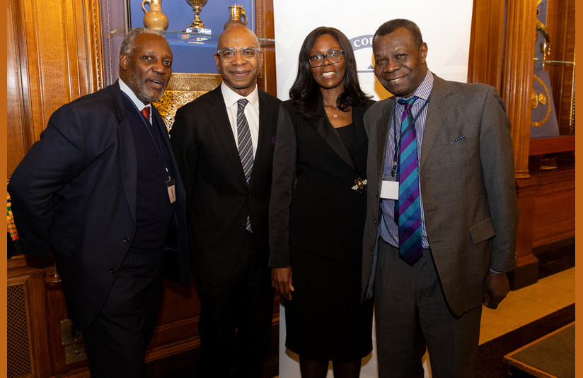 A photo of four people smiling at the camera