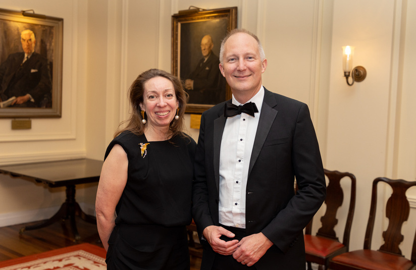 A photo of two people standing and smiling at the camera