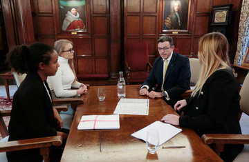 Group of barristers talking while sitting at a table.