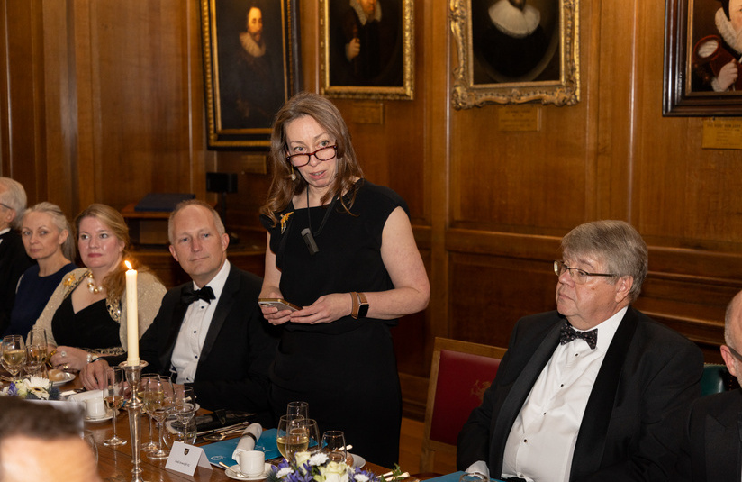 A photo of someone standing and addressing the room with a speech