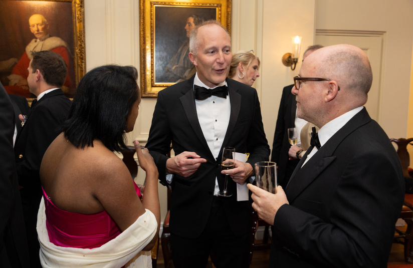 A photo of three people standing and talking