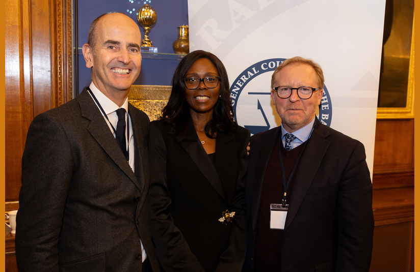 A photo of three people smiling at the camera