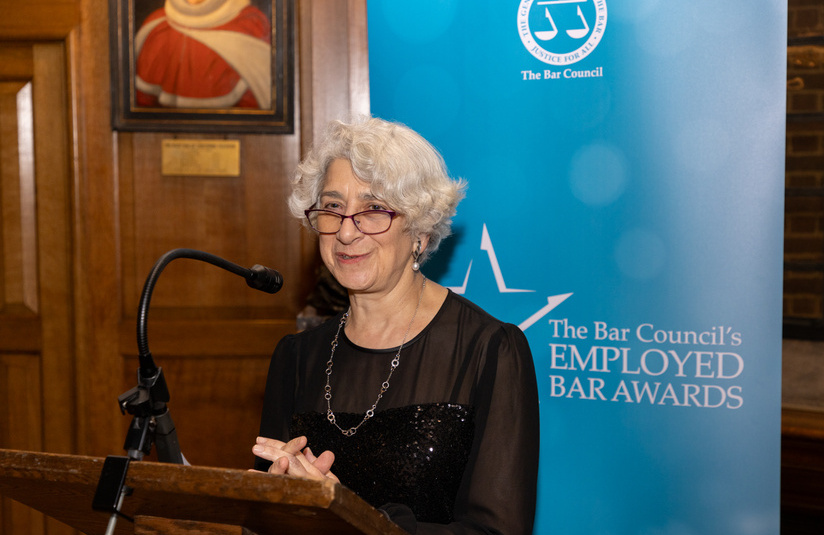 A photo of a woman speaking at the podium