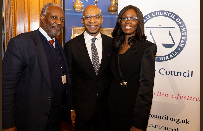 A photo of three people smiling at the camera